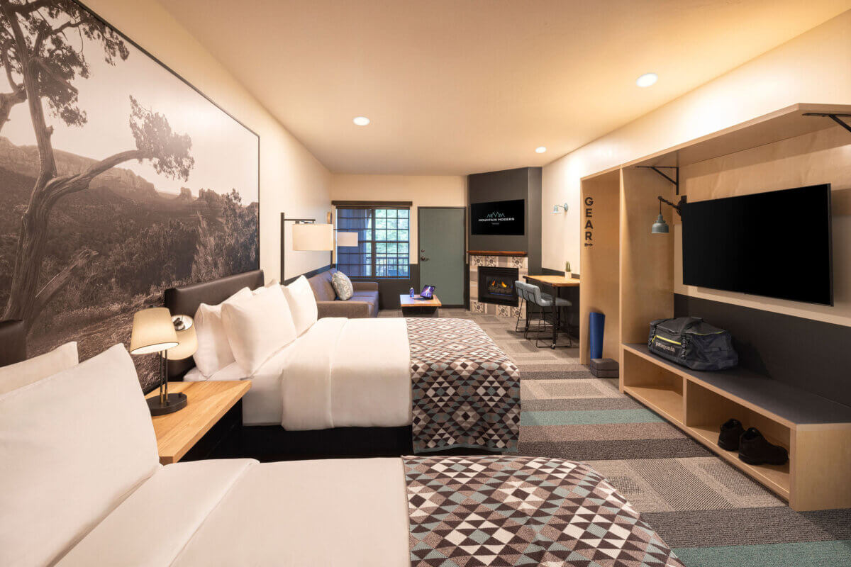 Two queen beds, sofa, fireplace, and patio in Two Queen Studio with Patio