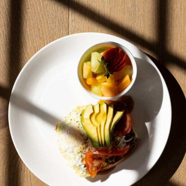 avocado toast with fruit on table in The Den