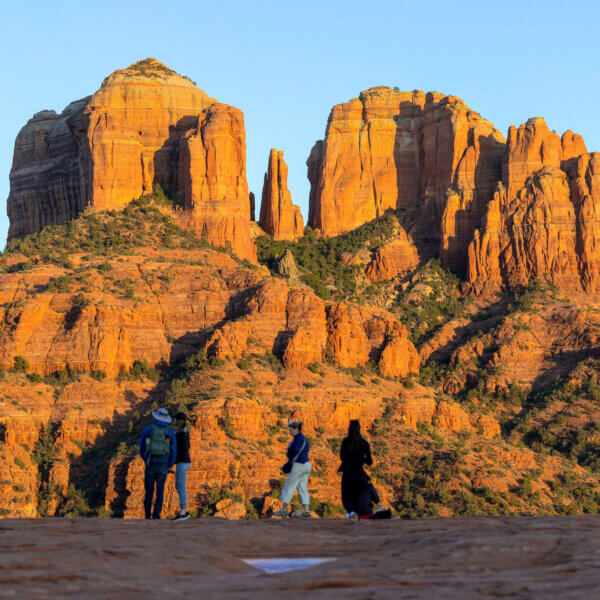 group of people sightseeing in front of Cathedral Rock