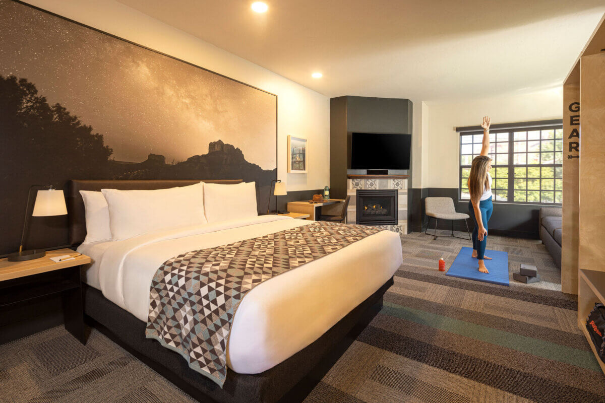 Woman doing yoga in King Studio in front of window, sofa and fireplace